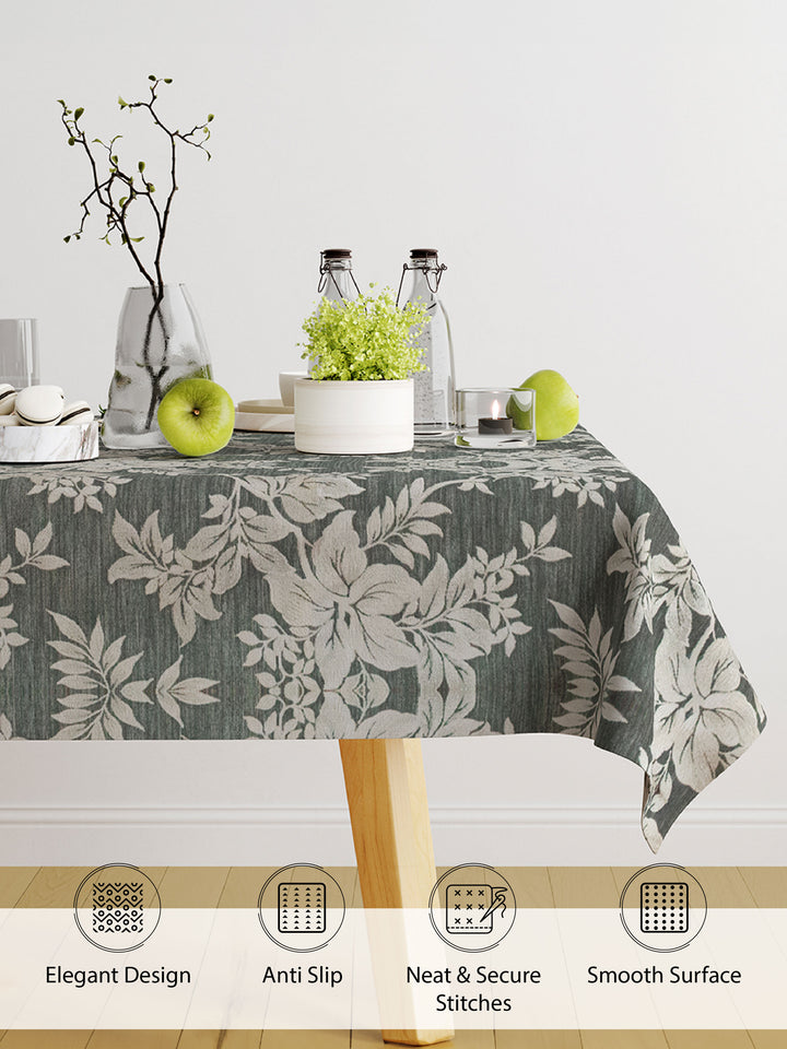 Tablecloth with floral pattern on a dining table with decor items.
