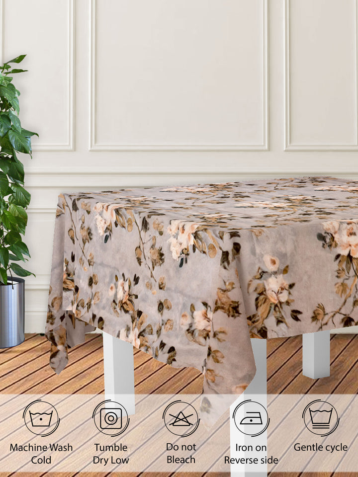 Floral patterned tablecloth on a wooden table with care instructions displayed.