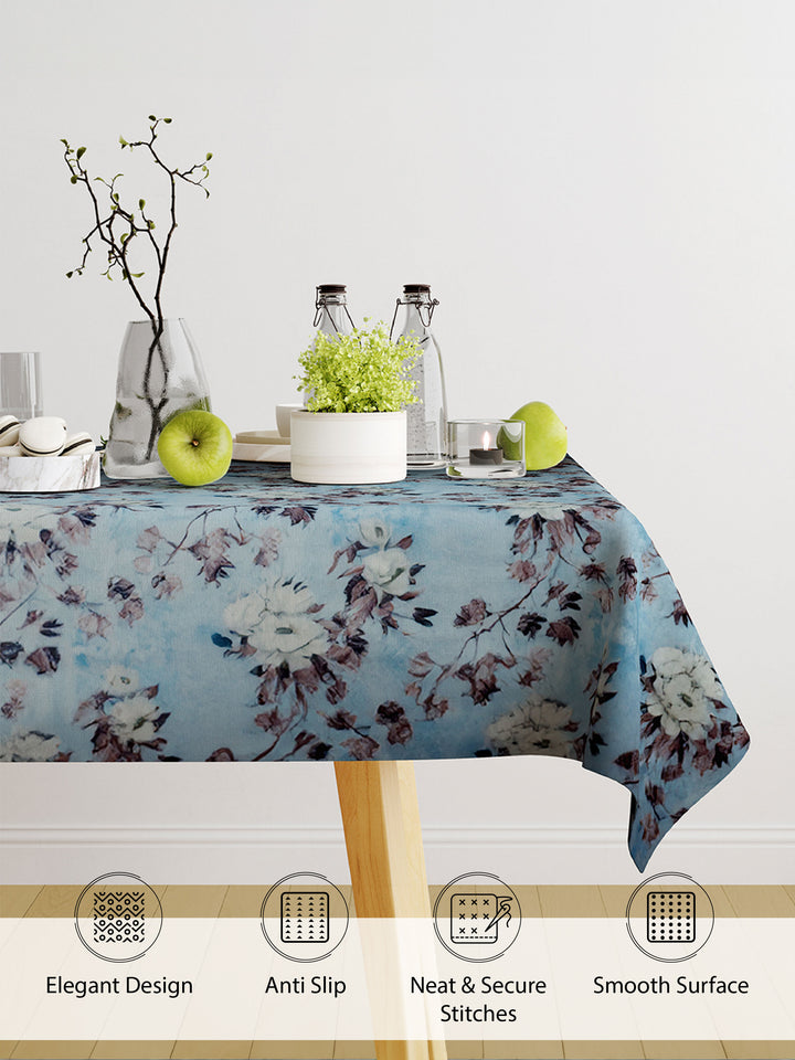 Floral patterned tablecloth on a table with decorative items, featuring text on product features.