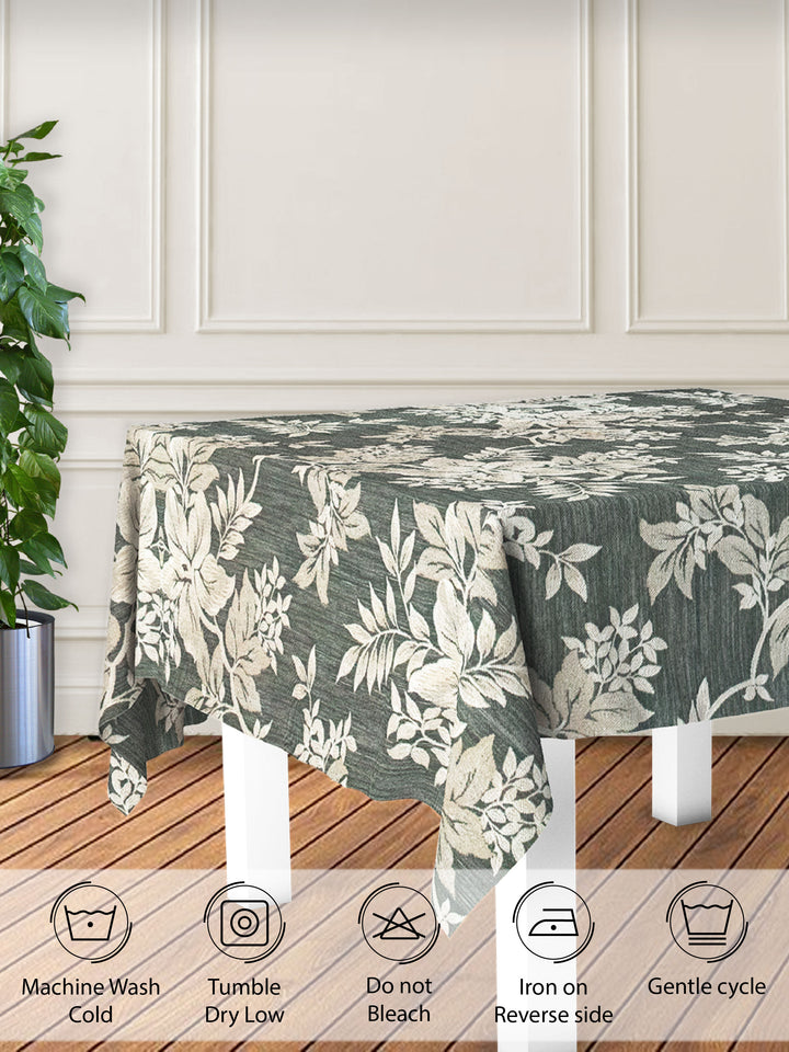 Floral patterned tablecloth on a wooden table with care instructions displayed below.