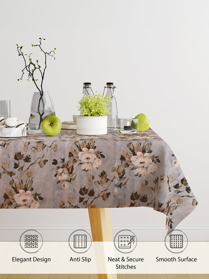 Floral patterned tablecloth on a table with decorative items against a white wall.