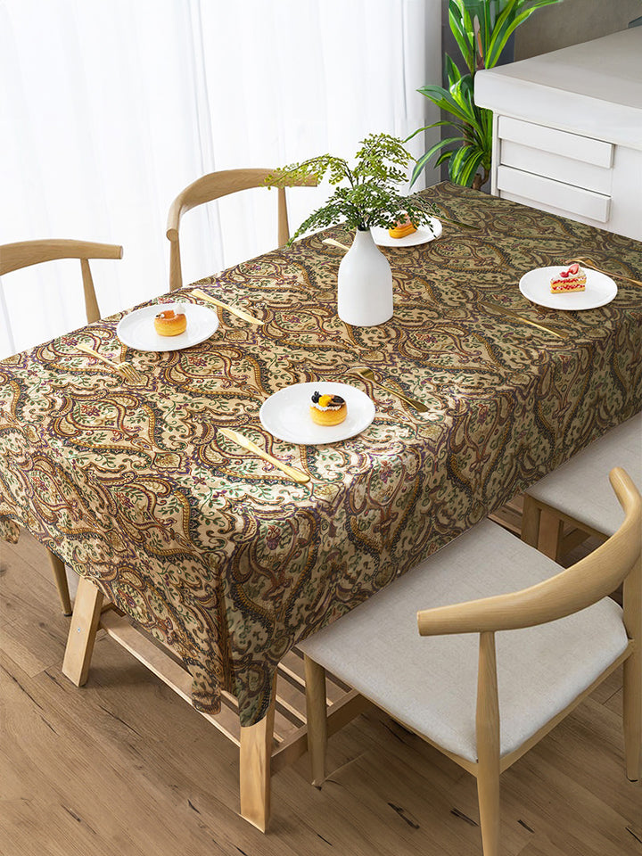 Dining table with a patterned tablecloth, plates with food, and chairs in a room.