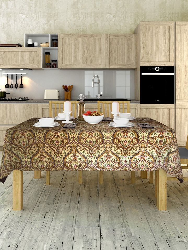 Kitchen with wooden cabinets, a table with a patterned tablecloth, and various kitchen items.