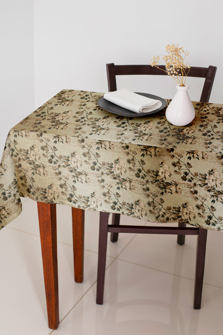 Dining table with floral-patterned tablecloth, chair, and decorative elements.