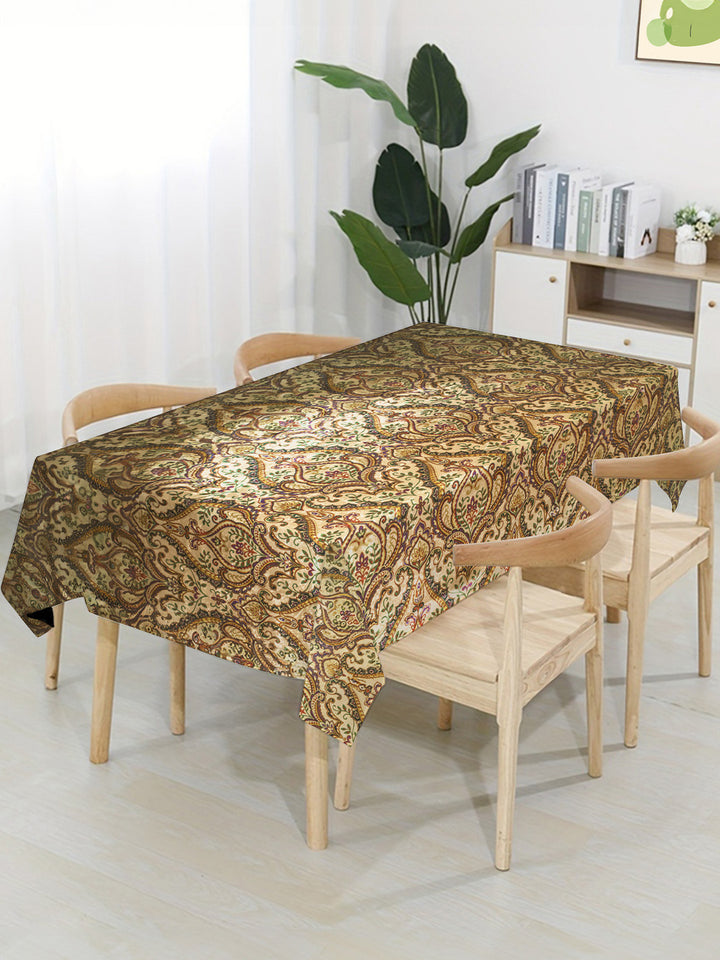 Dining table with a patterned tablecloth in a room with a plant and shelves.