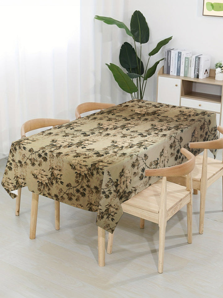 Dining table with a floral-patterned tablecloth in a bright room.