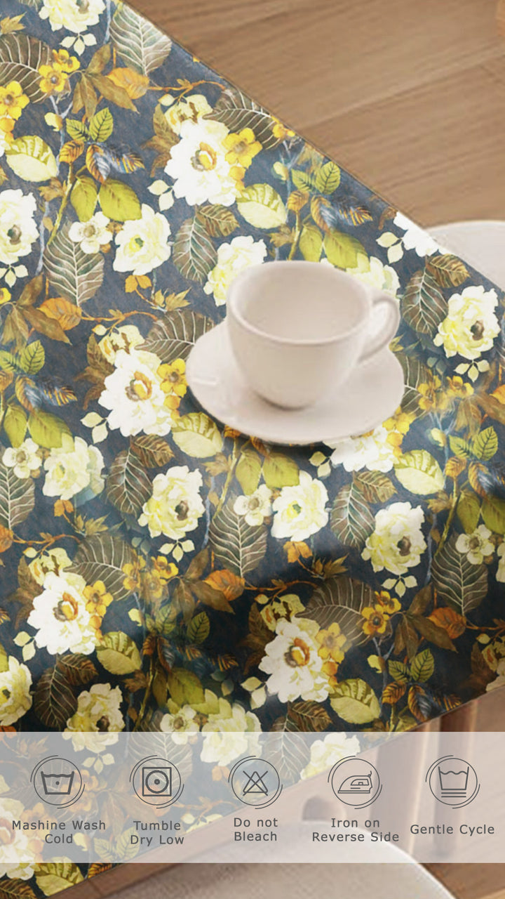 Floral-patterned tablecloth with a cup and saucer on a wooden surface