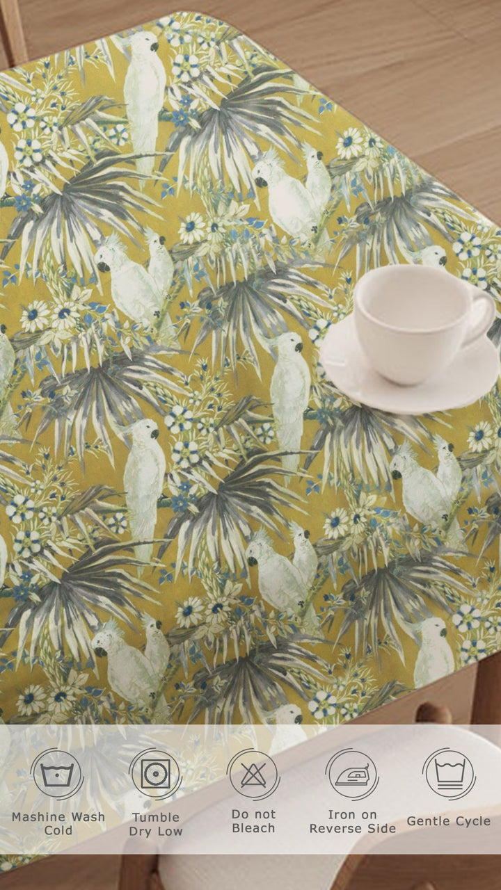 Tablecloth with parrot and palm tree pattern on a wooden table