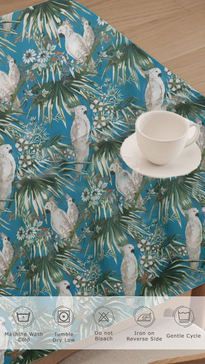 Table mat with tropical leaf and parrot pattern on a wooden surface