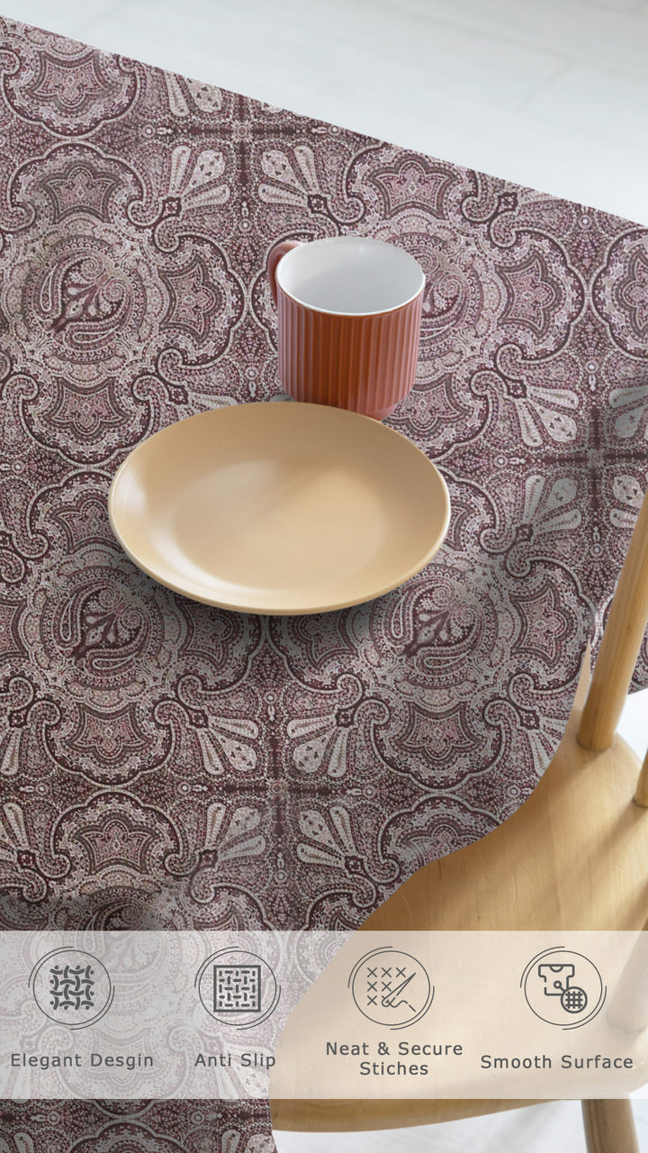 Patterned tablecloth with a cup, plate, and wooden spoon on a white background