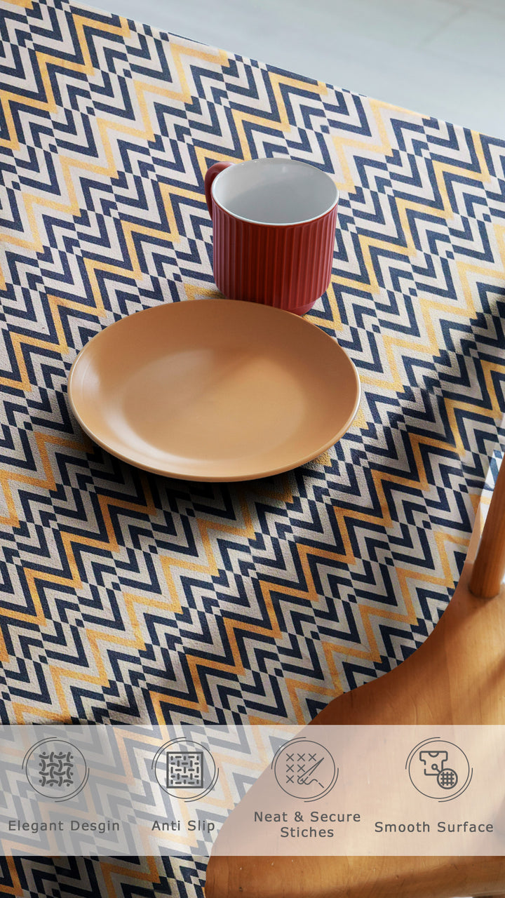 Table setting with a geometric patterned tablecloth, plate, and mug.