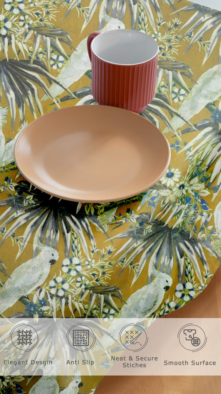 Table setting with a red mug and beige plate on a tropical-themed placemat.