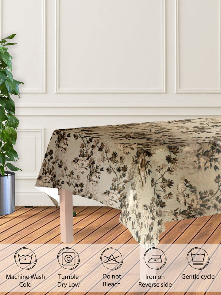 Floral patterned tablecloth on a wooden table with care instructions displayed below.