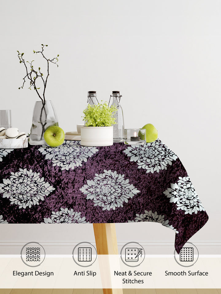 Tablecloth with floral pattern on a table with decorative items against a white background