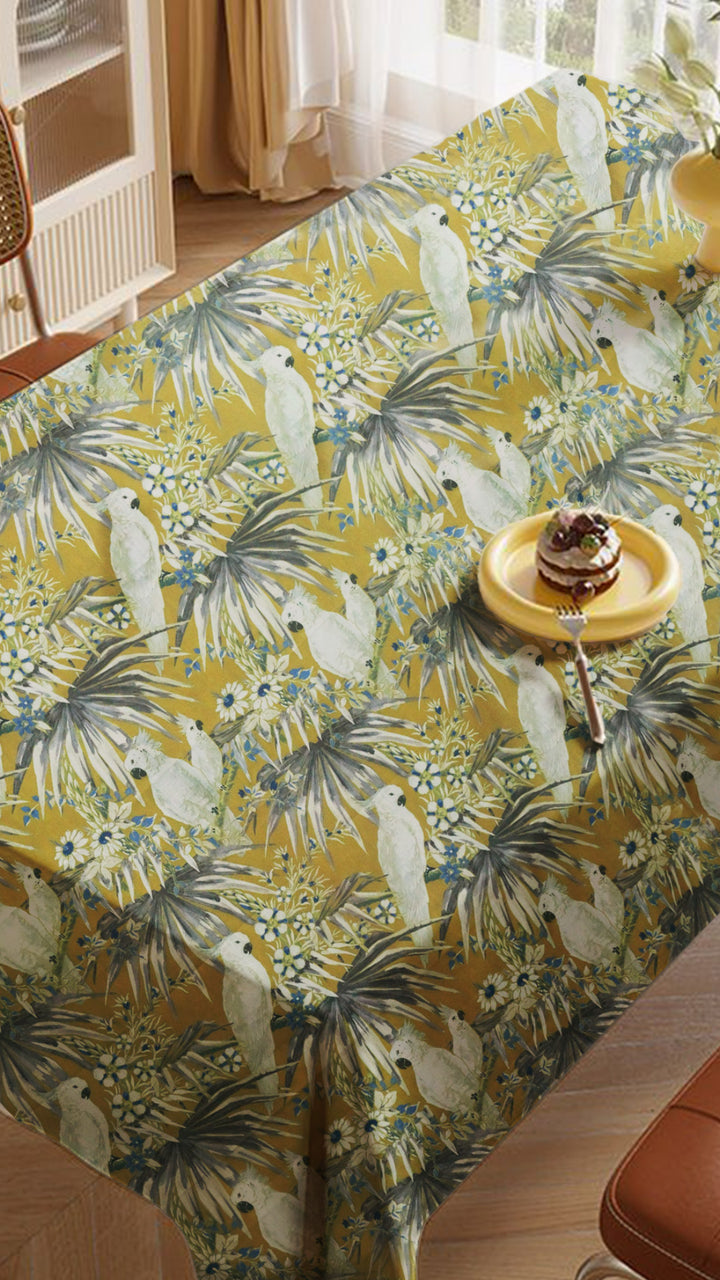 Tablecloth with tropical bird and palm tree pattern on a dining table.