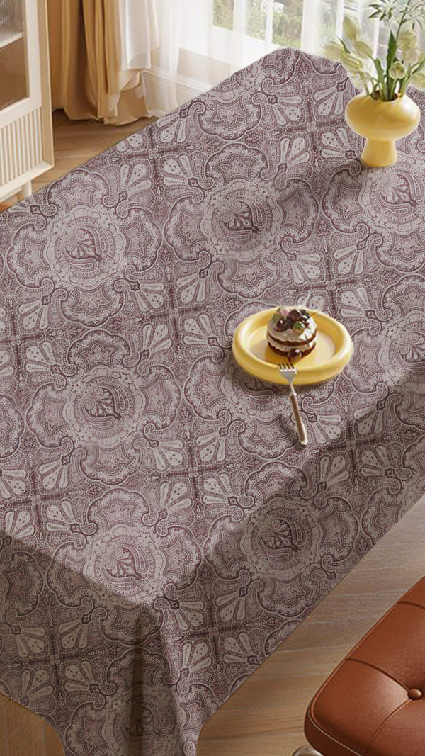 Patterned tablecloth on a dining table with a cake, set in a home interior.