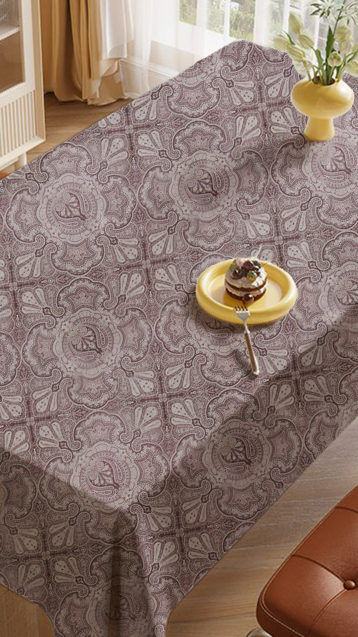 Patterned tablecloth on a dining table with a cake, set in a home interior.