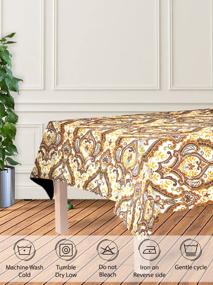 Decorative tablecloth with paisley pattern on a wooden table in a kitchen setting.